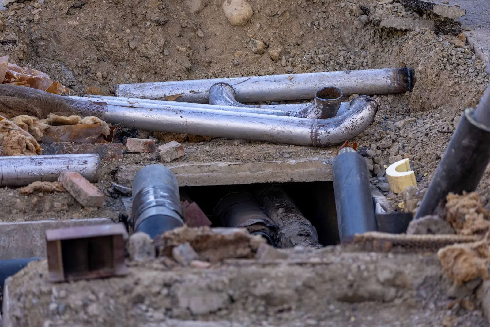 Exposed underground pipes and connections at a construction site